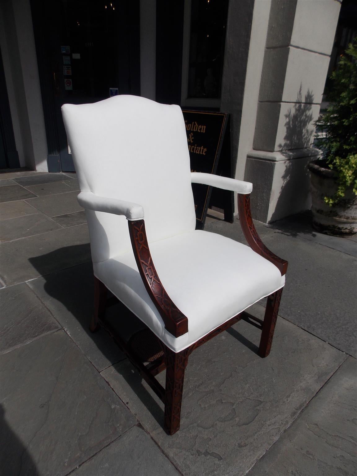 English Chinese Chippendale mahogany armchair with serpentine back, scrolled arms, intricately carved fret work, cross stretchers, and terminating on squared legs. Chair is upholstered in white muslin and retains the original horse hair, Late 18th
