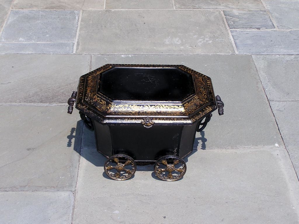 English tole coal hod with floral gilt stenciling, scrolled wrought iron handles, and original wheels. Coal hod has the original Tin removable insert.