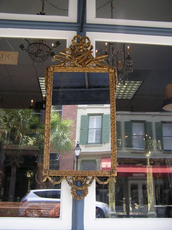 Italian carved wood gold gilt mirror with ribbon, lyre, and floral cartouche.
