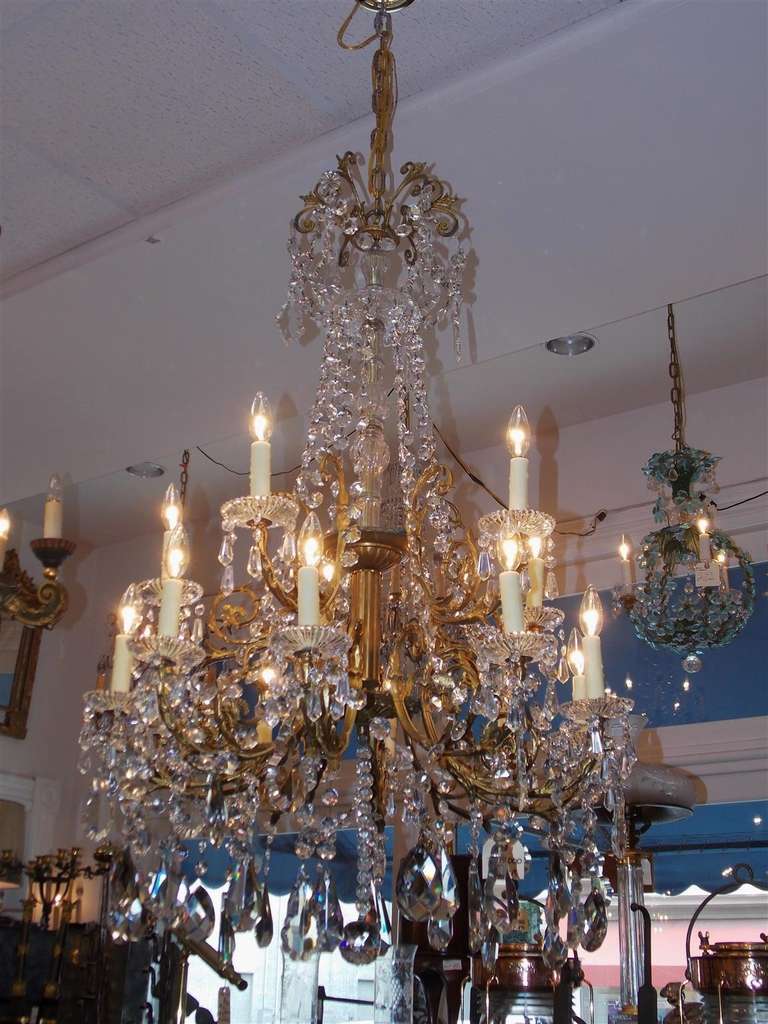 French gilt bronze and crystal fifteen light chandelier with crystal fluted centered column, scrolled floral decorative arms, and terminating with a faceted crystal ball.  Originally candle powered and has been electrified.  Early 19th Century.