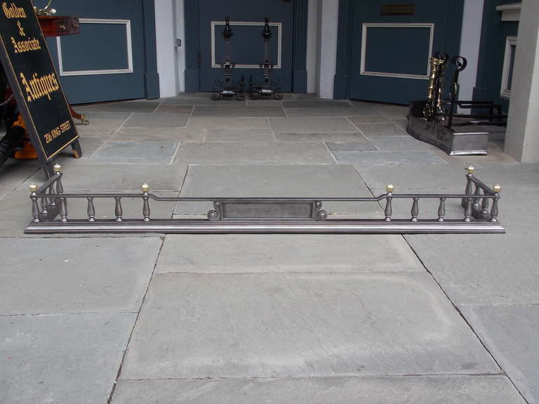 English brass and polished steel gallery fire fender with mellon finials and decorative centered scroll work. Early 19th Century