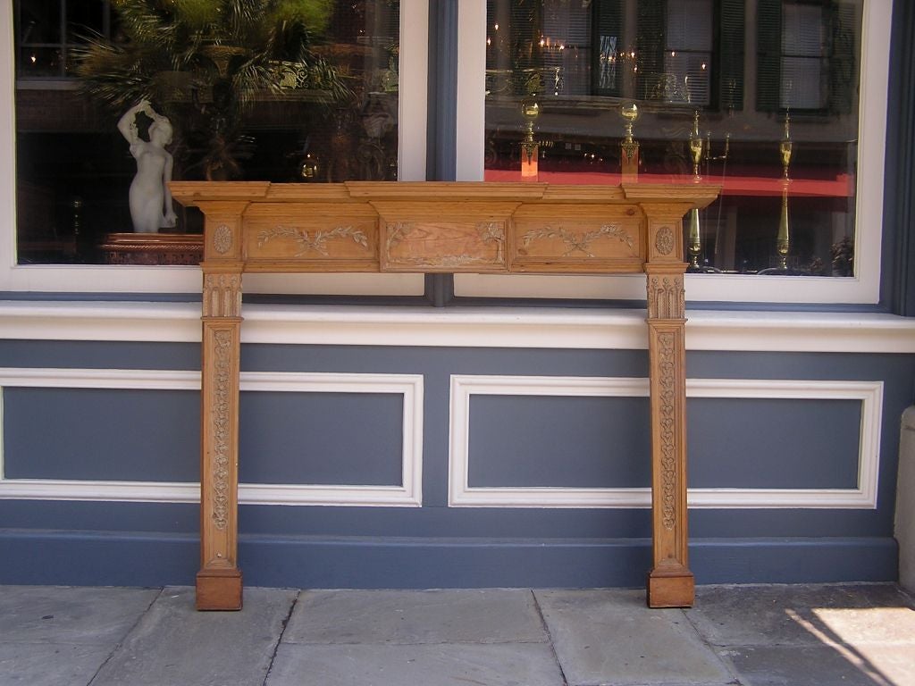 English Georgian Pine Classical mantle with original carved gesso, foliage, and medallion motif.  Late 18th Century. 

 Overall measurements- 67.25