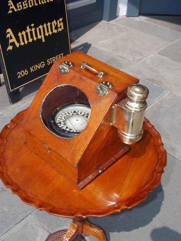 American mahogany yacht binnacle with oval glass viewing port, hinged door with eye hook, original solid brass side light, and carrying handle. Fitted with a compass by Ritchie. Compass is marked with merchants name Charles C. Hutchinson, Boston,