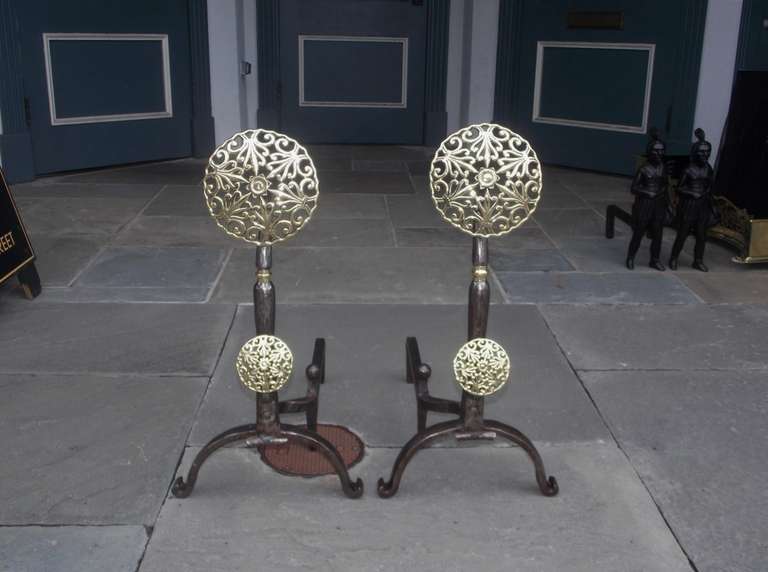 Pair of Italian brass and polished steel double medallion andirons with filigree and centered star, squared tapered plinths,  matching log stops, and terminating on scrolled legs.  Early 19th Century