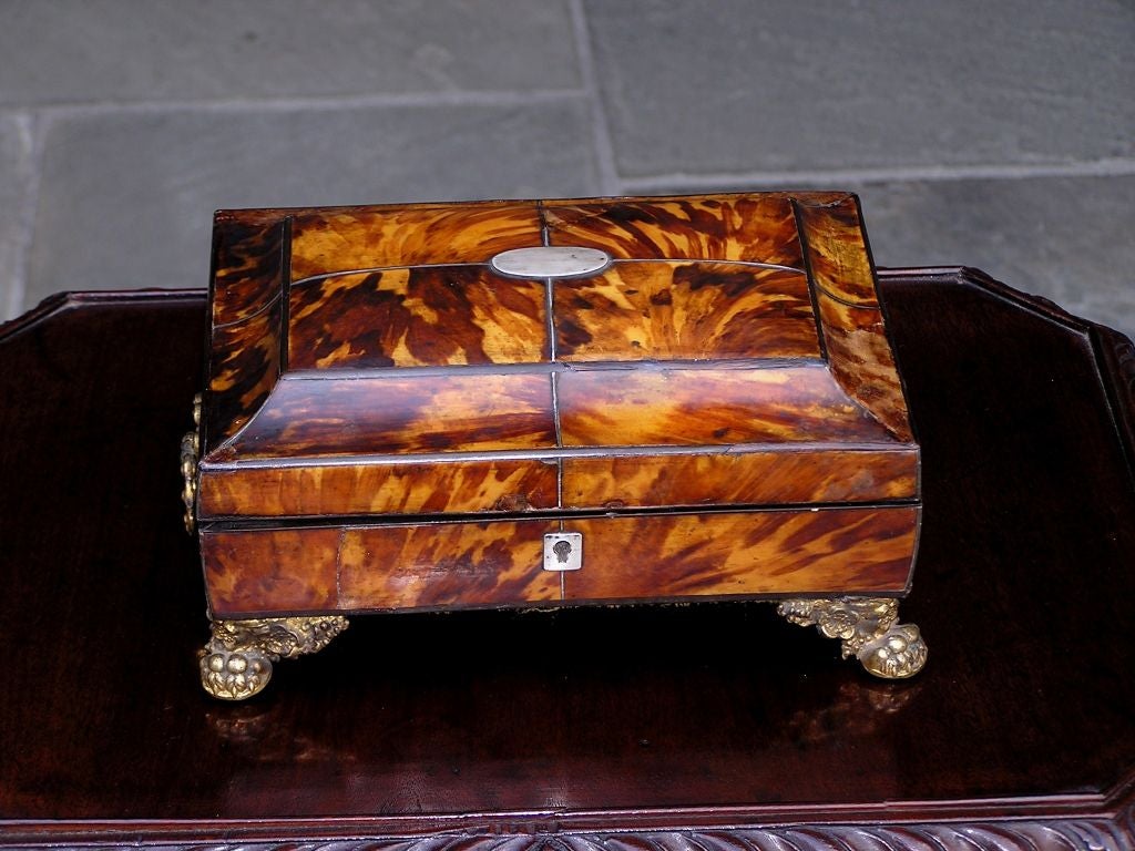 English Tortoise shell sewing box with original gilt bronze handles, claw feet, ivory escutcheon, and paktong mount. The interior is fitted and has original sewing accessories.
