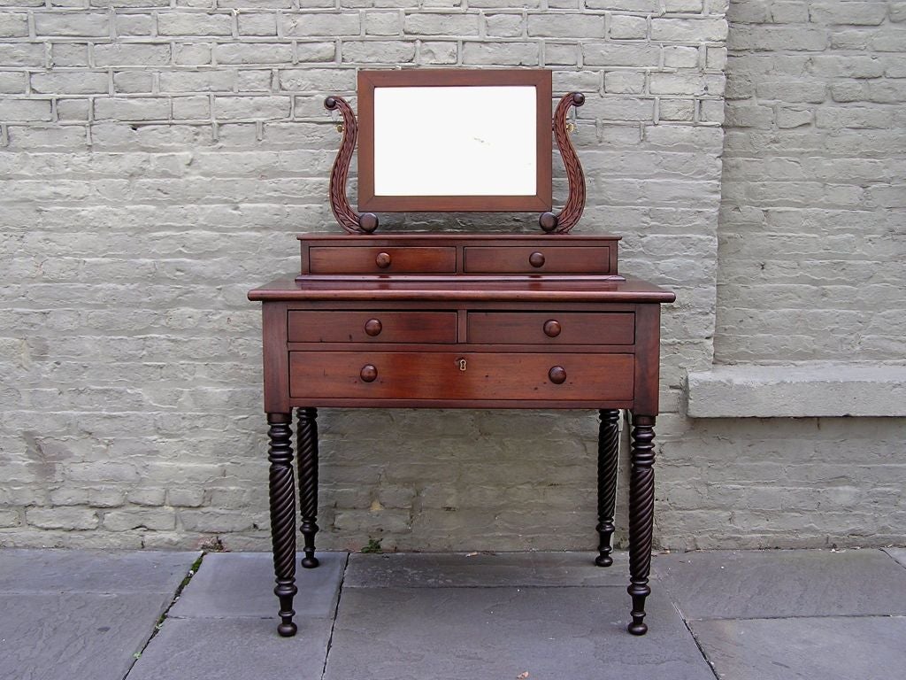 Caribbean mahogany two piece five drawer dressing table with acanthus carved stiles, original wood knobs,  adjustable mirror with wood back, and terminating on turned ringed barley twist legs with ball feet. Early 19th Century