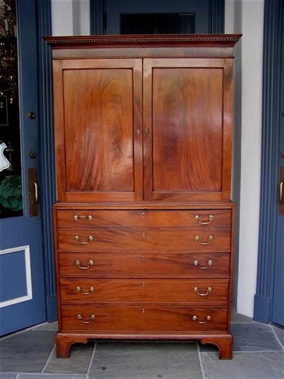 Charleston mahogany linen press with carved dental molding, interior pull out slide drawers, fall front desk, original brasses, and ending on incised beveled feet. All original.