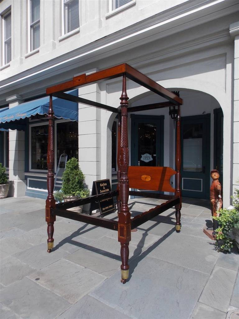 Charleston mahogany inlaid four poster Rice Bed with patera inlaid headboard, patera tester, turned ringed rice post with brass feet and wood casters. Descended in the Leonard family of Charleston.  Early 19th Century.