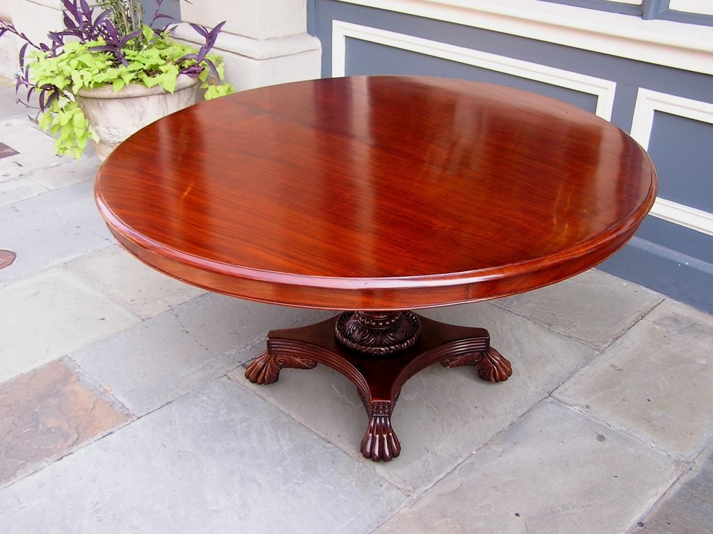 Caribbean mahogany center table with carved reeded bulbous pedestal, scrolled floral motif, and ending on lions paw feet with original brass casters. ( Barbados ) Early 19th century