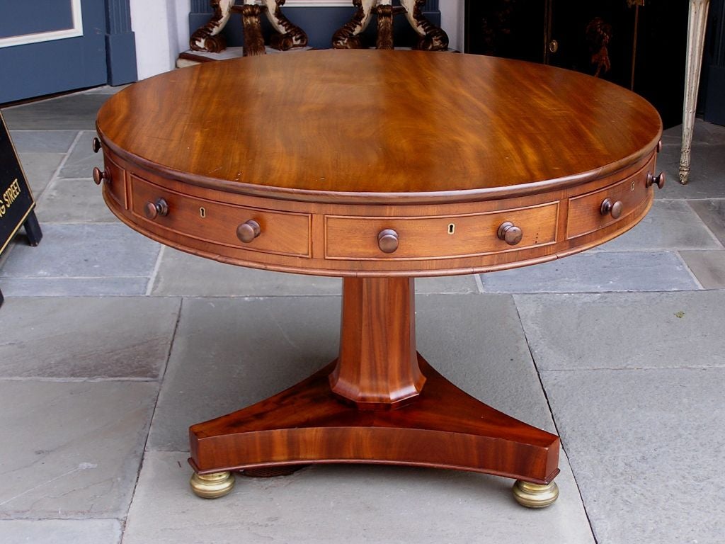 English mahogany rent table with faux and four drawer circular top, octagon pedestal, triangular base, and ending on ormolu bun feet with casters.