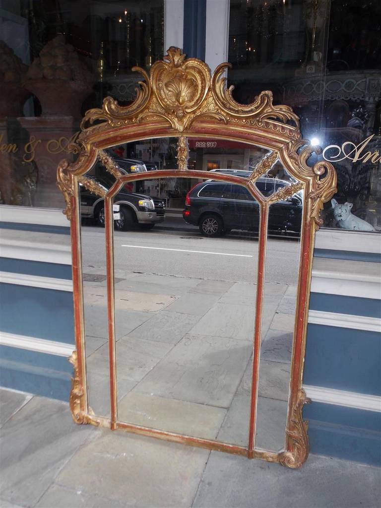 French gilt carved wood and red lacquer wall mirror with decorative floral cornice, egg and dart molded edge, and lower flanking acanthus carved corners. Mirror retains the original looking glass. Late 18th Century