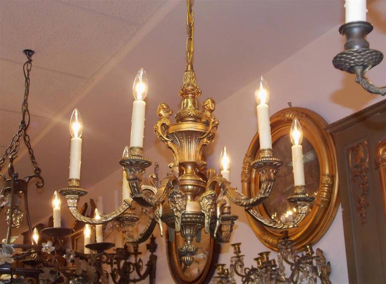 Italian gilt bronze six light chandelier with centered bulbous floral urn, figure heads of lady and Greek God motif. Early 19th Century.