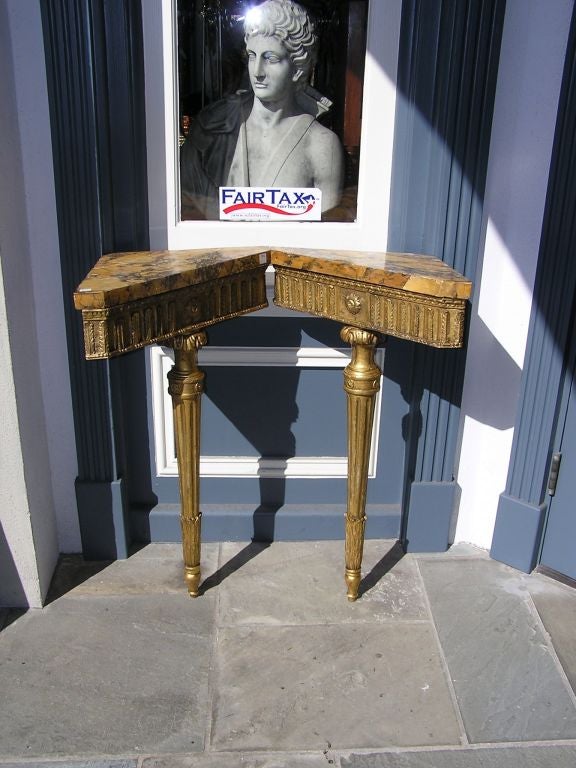 Pair of English gilt carved wood and marble top corner consoles with floral and fluted leg motif. Original marble tops.