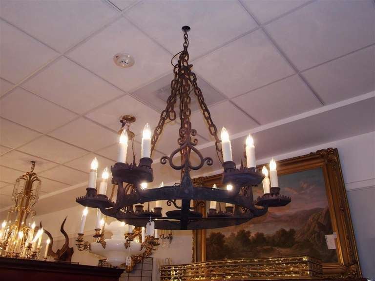 French wrought iron twelve light chandelier with decorative spike and scroll motif.  Originally candle powered. Early 19th Century