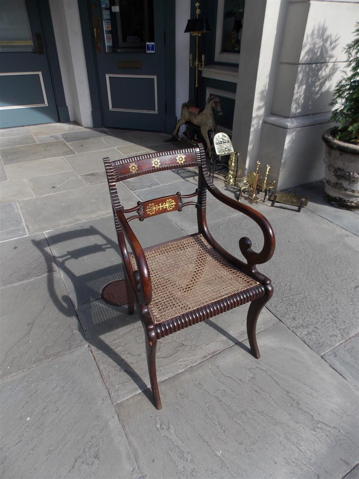 English Regency brass inlaid & faux painted Rosewood arm chair with gadrooning, cane seat, scrolled arms, and terminating on saber legs.  Great desk chair. Early 19th Century.