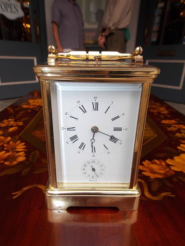 French brass beveled glass carriage clock with carrying handle, porcelain face with dial, and hand painted oval figural scenes. Clock consist of time, strike, alarm, and repeat. Clock was manufactured in France Late 19th Century