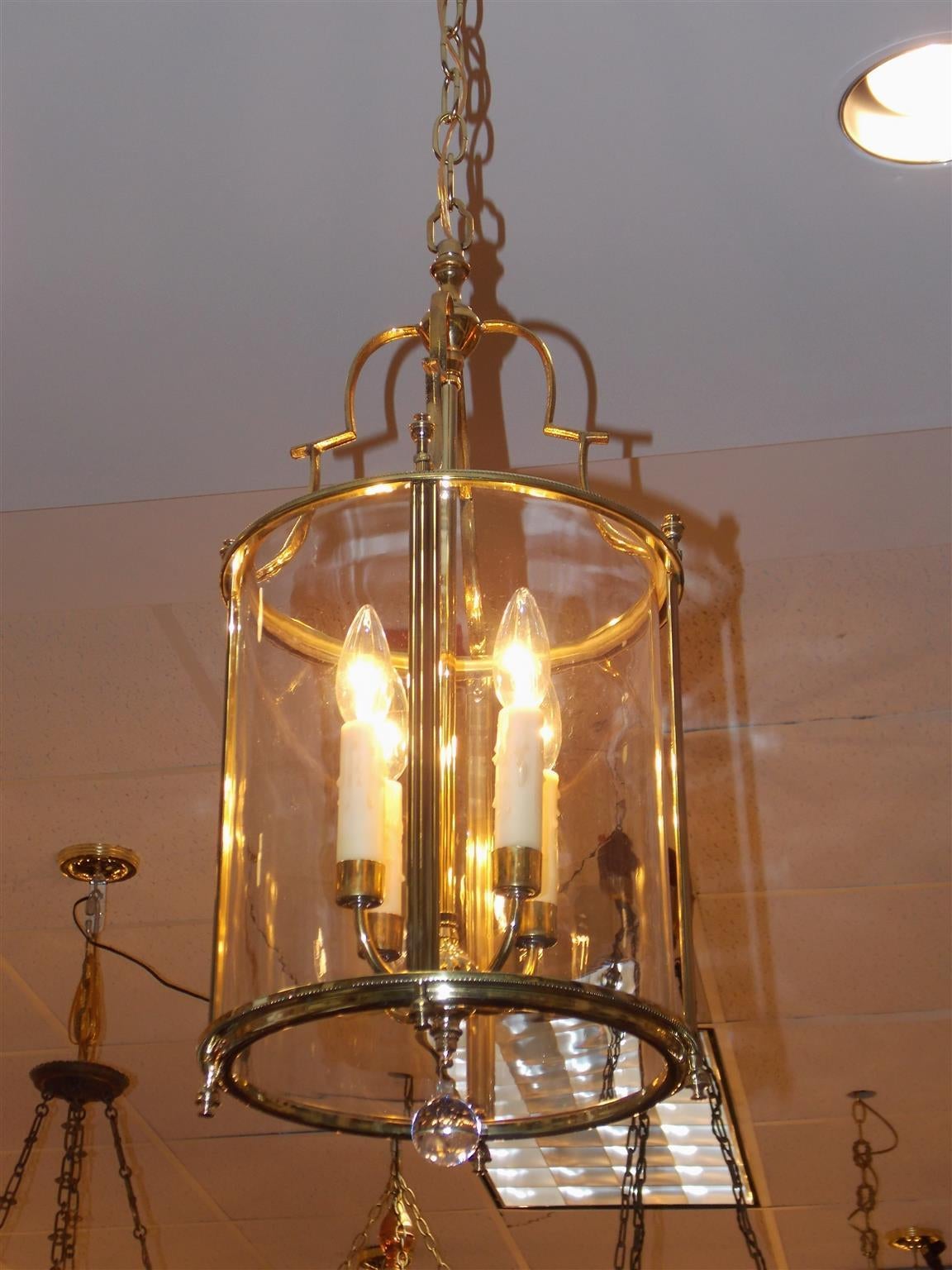 American brass four-light circular glass hanging lantern with decorative scrolled arms, urn finials, beaded chase work, and terminating with crystal ball, Mid-19th Century.