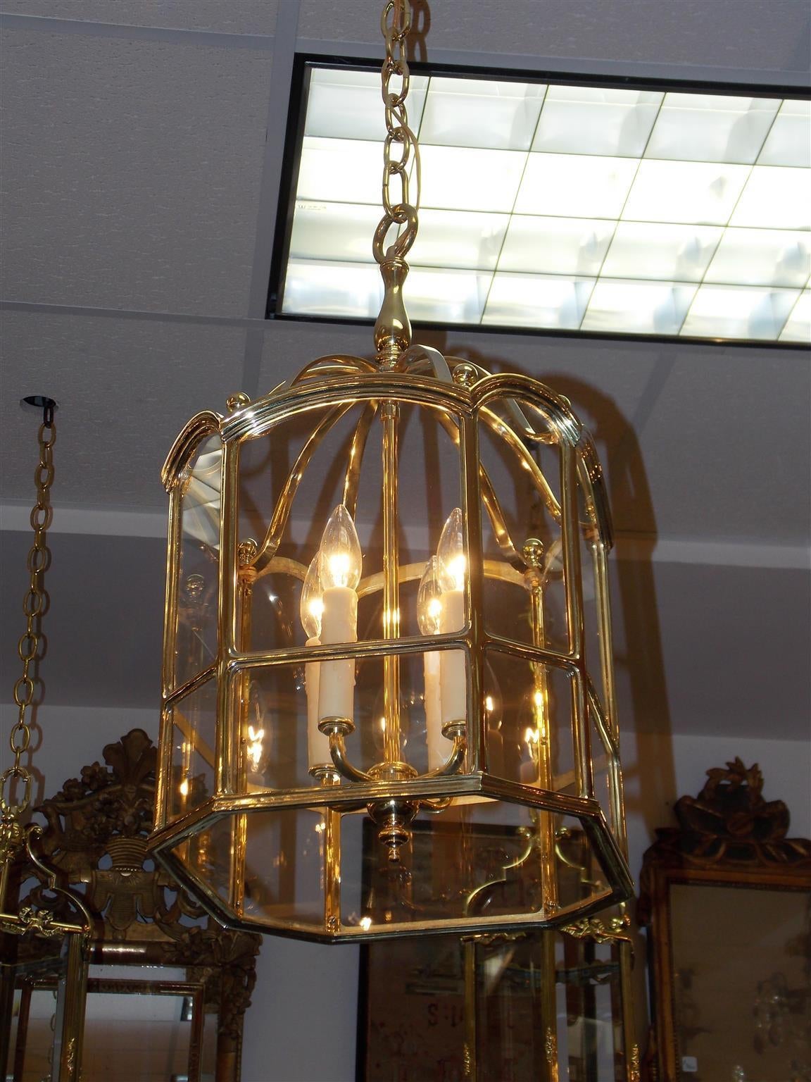 American brass four-light octagonal shaped hanging glass lantern with centered supporting ring, scrolled arms, ball finials, and terminating on a beveled molded edge, Mid-19th century.