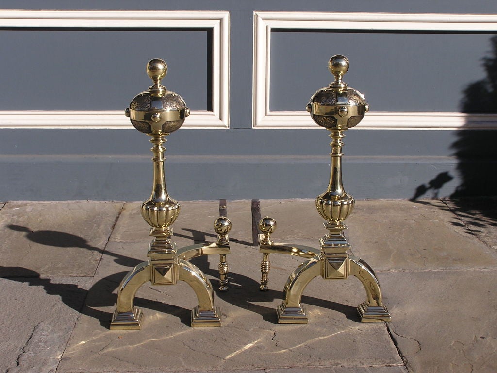 Pair of Italian brass ball top andirons with fluted plinths, ball finial log stops, and ending on scrolled squared feet.