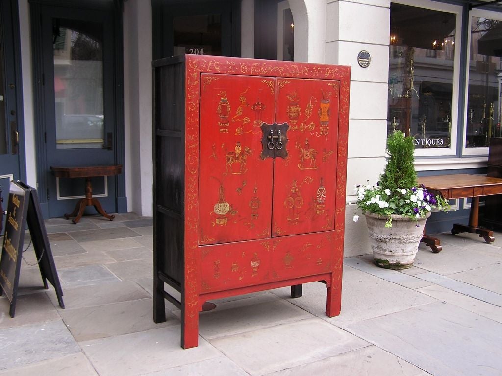 English chinoiserie two door painted cabinet with fitted inerior shelving, original bronze locking mechanism, and ending on original carved squared feet.