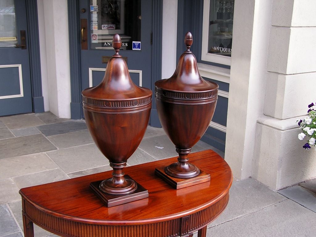 Pair of American mahogany flanking Urn telescopic cutlery boxes with acorn finials, fluted medallion gallery, original interior cutlery slots, and resting on turned ringed circular squared bases. Early 19th Century