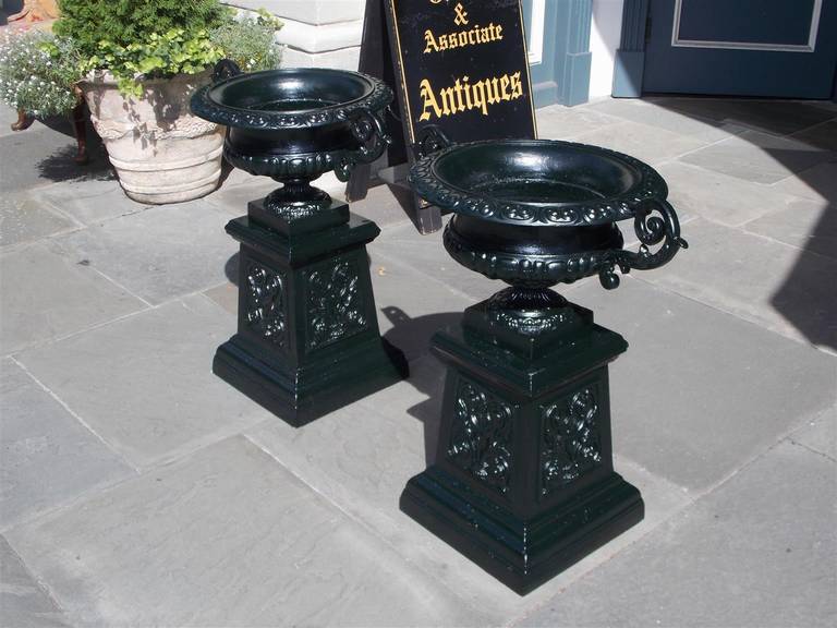 Pair of American cast iron foliage planters with scrolled handles, and terminating on raised squared floral plinths.  Late 19th Century. Planters have been powder coated.  Bases are 14.75