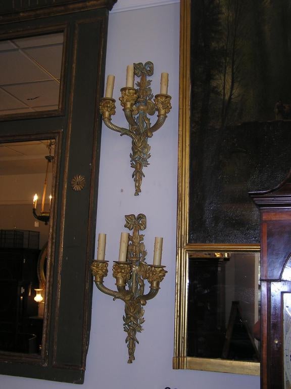 Néoclassique Paire d'appliques italiennes à trois bras en bronze doré et ornementation de rubans et de feuillages. Datant d'environ 1820 en vente