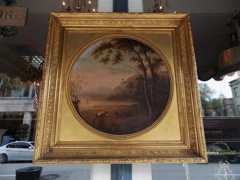 American oil on canvas landscape with resting cows in foreground,  and fishermen in background. Painting is in original gilt carved floral frame.  Dealers please call for trade price.