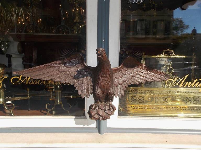 American carved walnut perched eagle with spread wings on rocky plinth.  Mid 19th Century