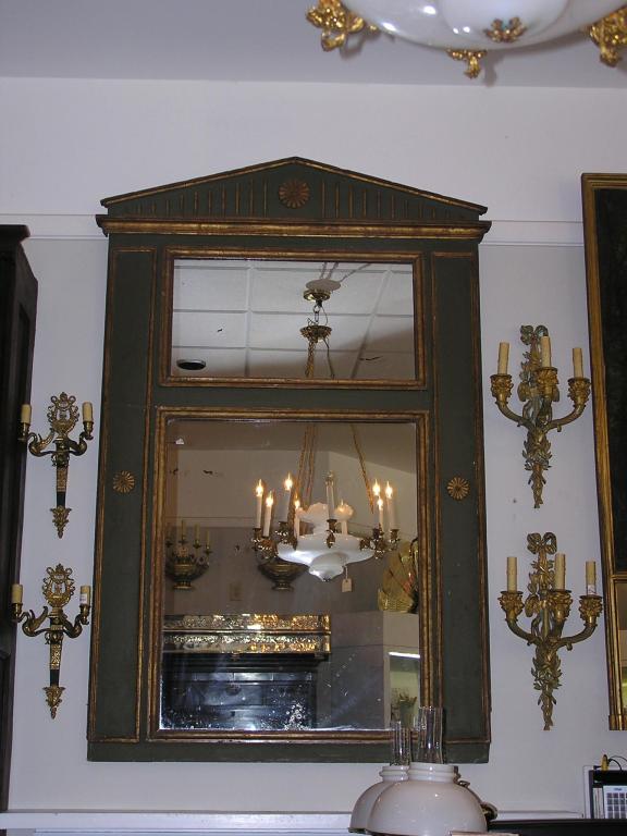 French Palladian painted and gilt trumeau mirror with a fluted carved cornice and flanking floral medallions. Early 19th Century. Mirror retains the original silvered glass & wood backing.