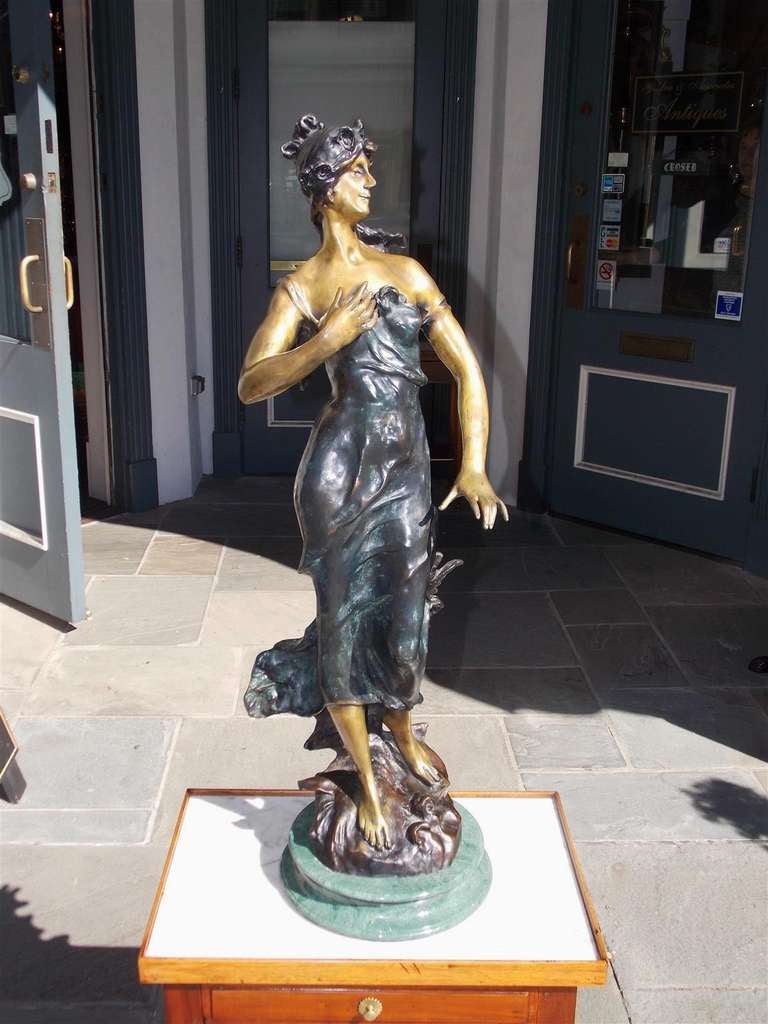 French bronze statue of standing lady on circular marble base.