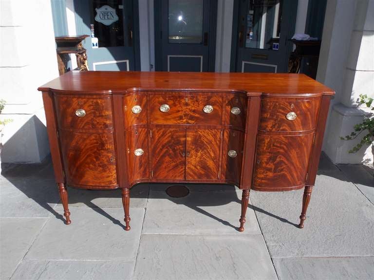 American mahogany seven drawer sideboard with lower  flanking cabinets, period brasses, and terminating reeded turned bulbous  legs.  Attributed to Thomas Seymour, Boston.