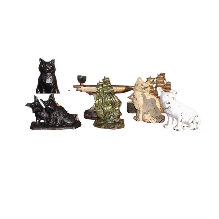 Grouping of cast iron hand painted door stops.  Set consist of  dogs, cats, ships, and anvil. Late 19th early 20th Century.