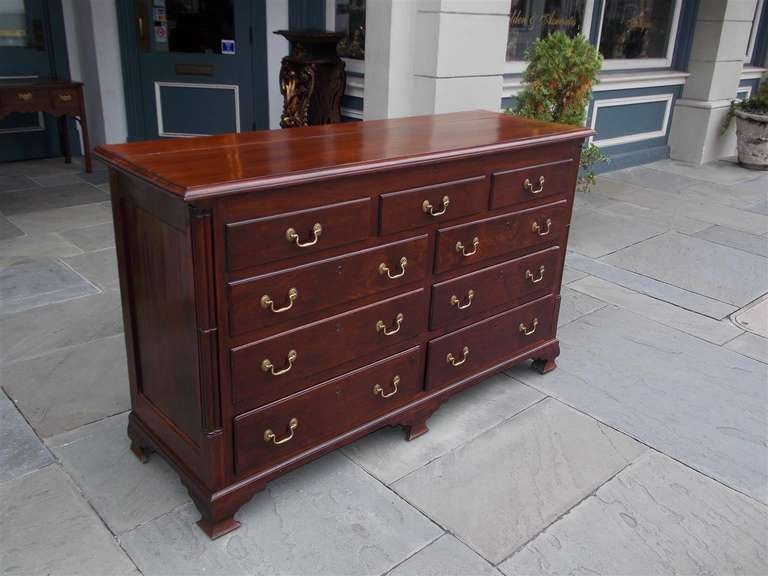 English Chippendale mahogany mule chest with a hinged lid revealing an interior two drawer till, faux three over two drawers, four lower drawers, original brasses, flanking corner columns, and terminating on the original ogee bracket feet. Mid 18th