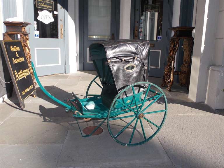 English child's two wheel hand painted rickshaw with leather bonnet top. Circa 1880