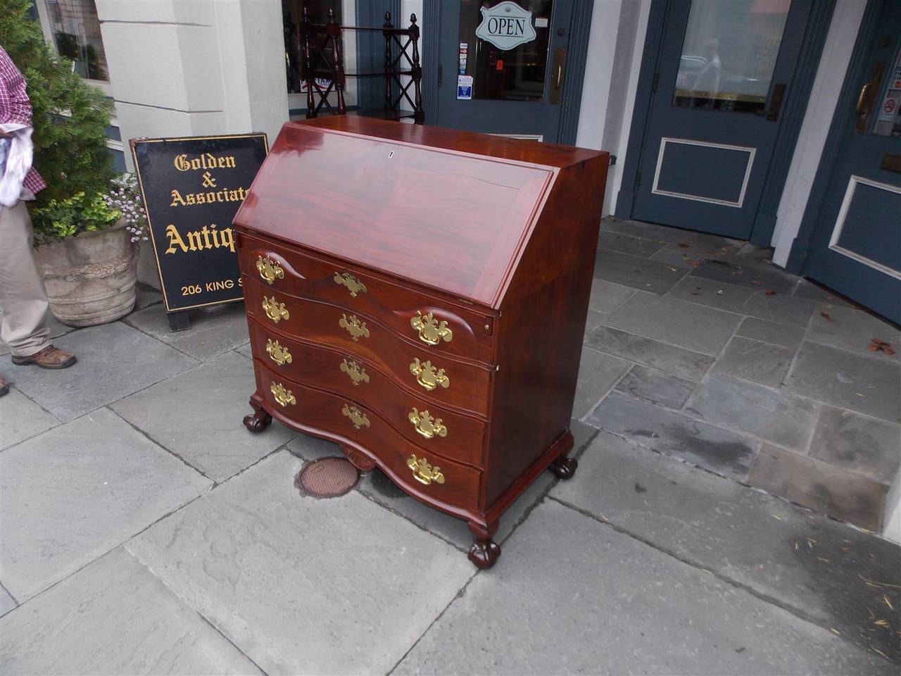 American Chippendale mahogany oxbow slant top four drawer desk with exposed dove tail, original brasses, fitted interior, shell carved skirt,  and terminating on original claw and ball feet. Boston, Late 18th Century