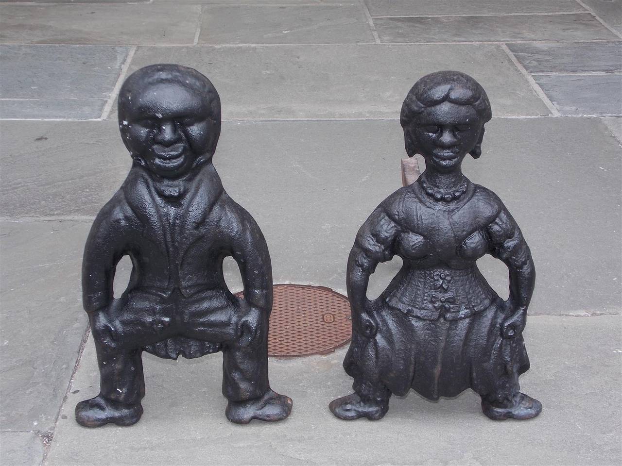 Pair of American cast iron squatting figural andirons of man and woman with original dog legs. Mid 19th Century