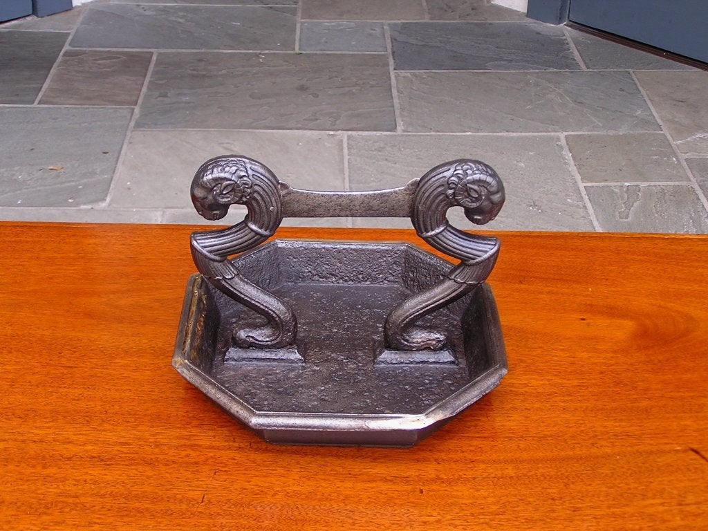 English Regency cast iron boot scrape with rams head motif and terminating on fluted scrolled supports on octagon base.