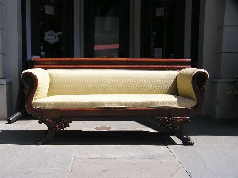 American mahogany classical upholstered sofa with swans head arm rest, carved corner cornucopia, and terminating on ebonized lions paw feet. Philadelphia.