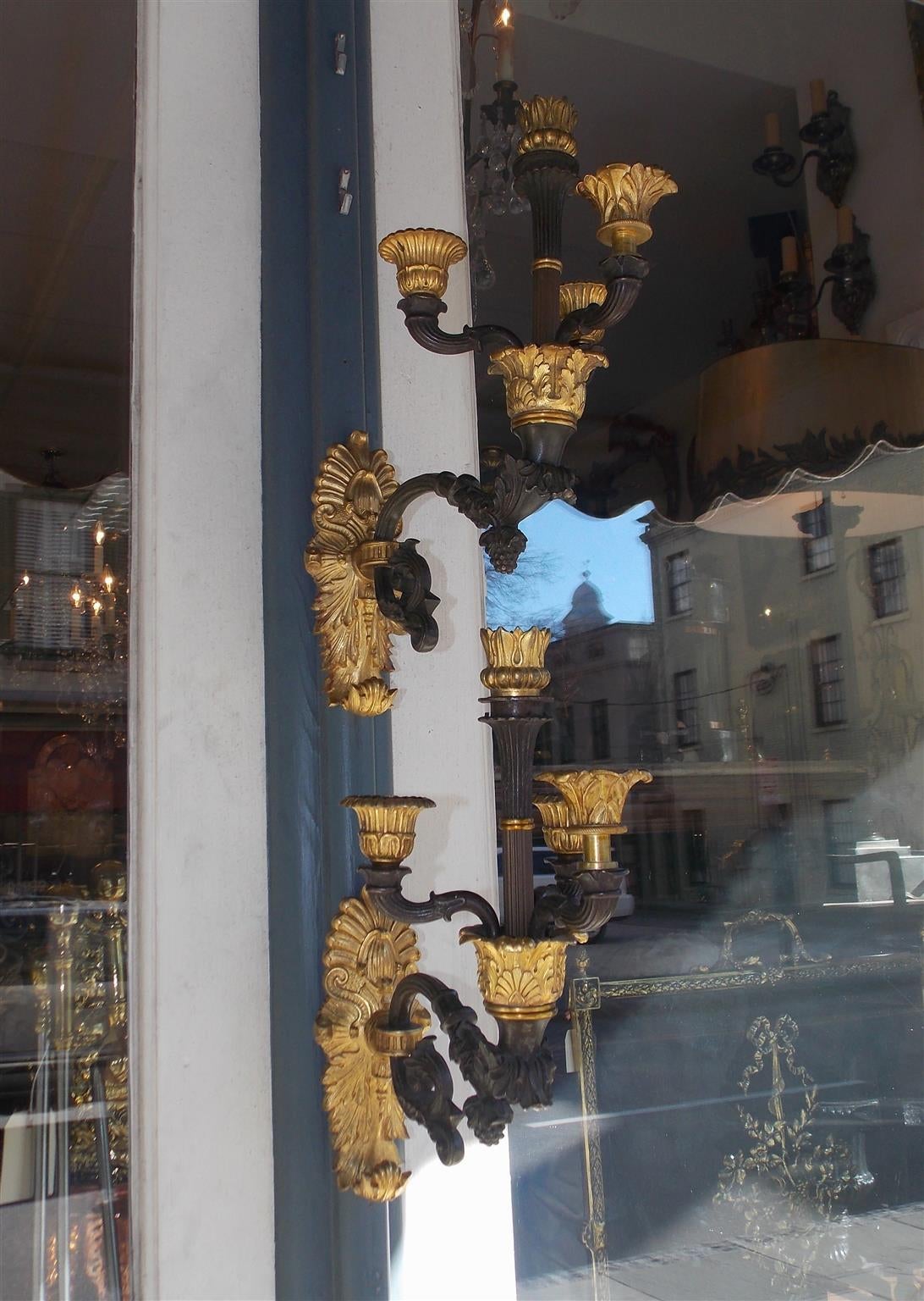Coppia di applique francesi in bronzo dorato a braccio singolo a quattro candele con motivo decorativo floreale e a volute. Alimentato a candela e può essere elettrificato, inizio del XIX secolo.
