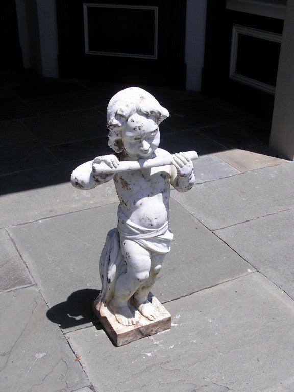 Statue en marbre français représentant Pan jouant de la flûte, assis sur un tabouret de jardin et reposant sur une base carrée.