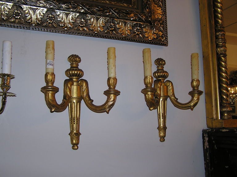 Pair of French carved wood gold gilt two arm sconces with floral and urn motif. Originally candles. 