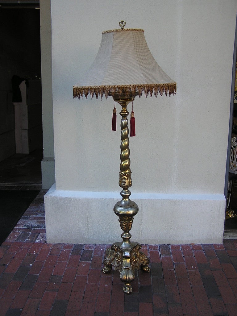 French gilt bronze two light floor lamp with scrolled twisted shaft, connecting to lower floral bulbous urn, and terminating on tripod floral claw base with decorative figure.  Dealers please call for trade price.