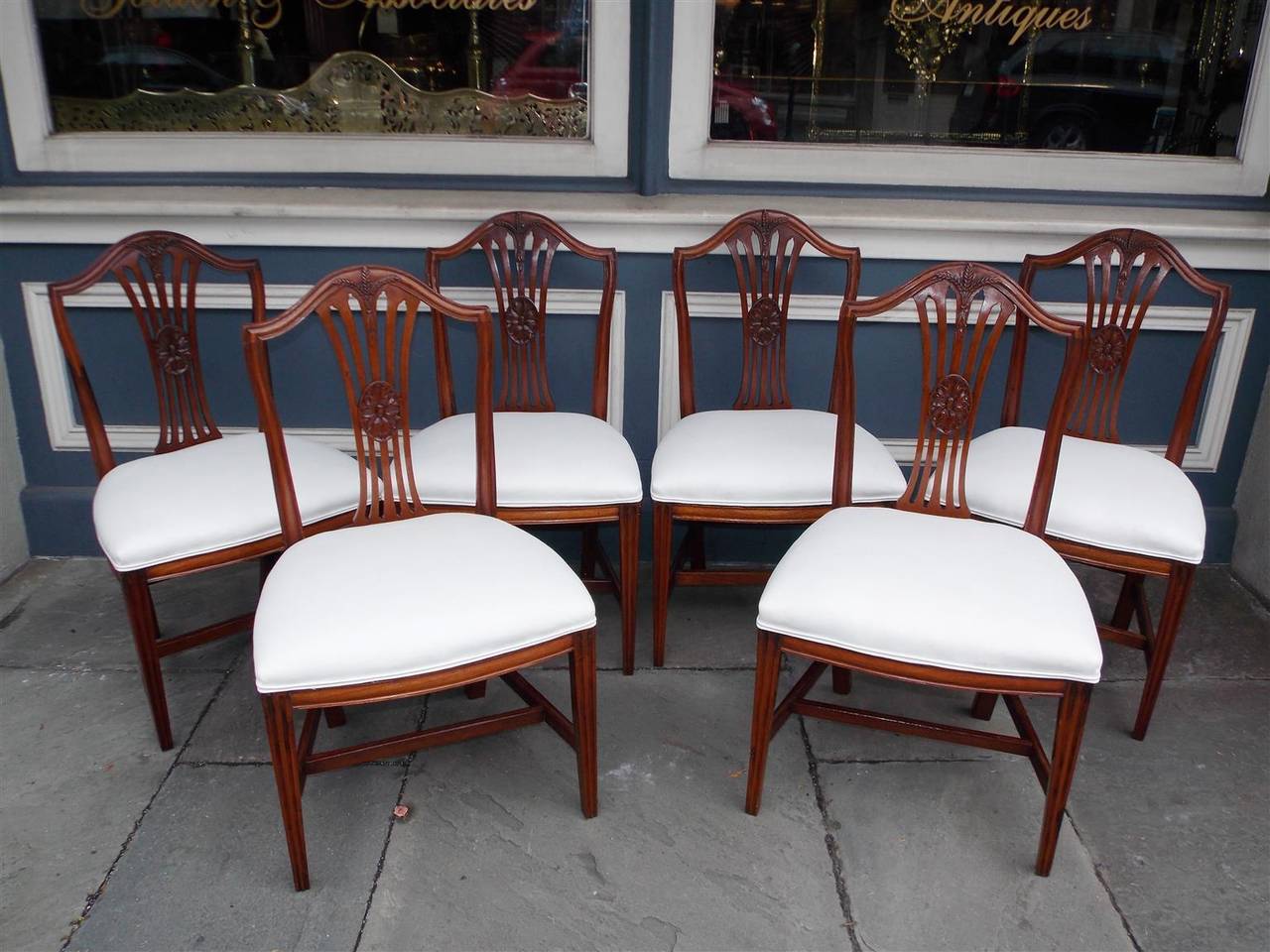 Set of Six American Hepplewhite mahogany period side chairs with carved splat backs consisting of wheat sheaths and centered floral oval medallions, seat bottoms are upholstered in white muslin with horse hair and cotton padding, original cross