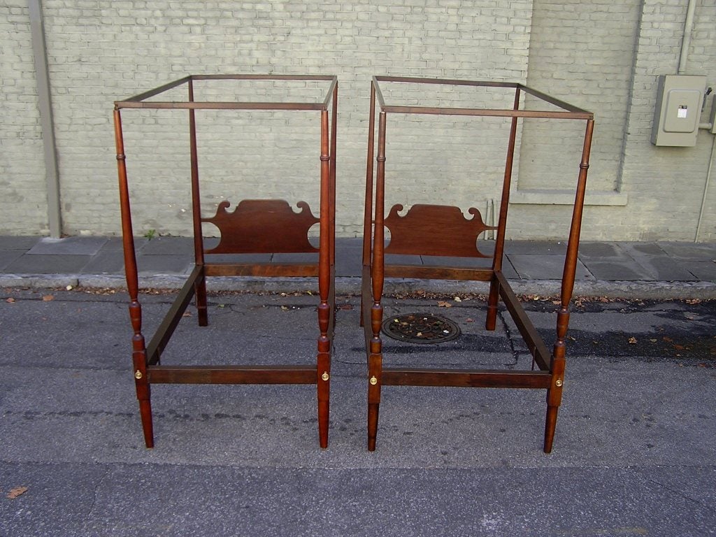 Pair of American mahogany pencil and bulbous post twin tester beds with original carved scrolled headboards, brass escutcheons, and side rails.  Fits Standard twin mattress and box springs. Early 19th Century