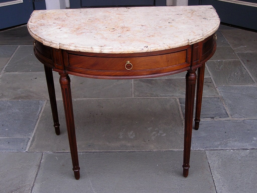 Italian Walnut one drawer demi-lune marble top console with ring pull brasses, incised moldings, and resting on the original turned bulbous fluted legs. Late 18th Century. All original
