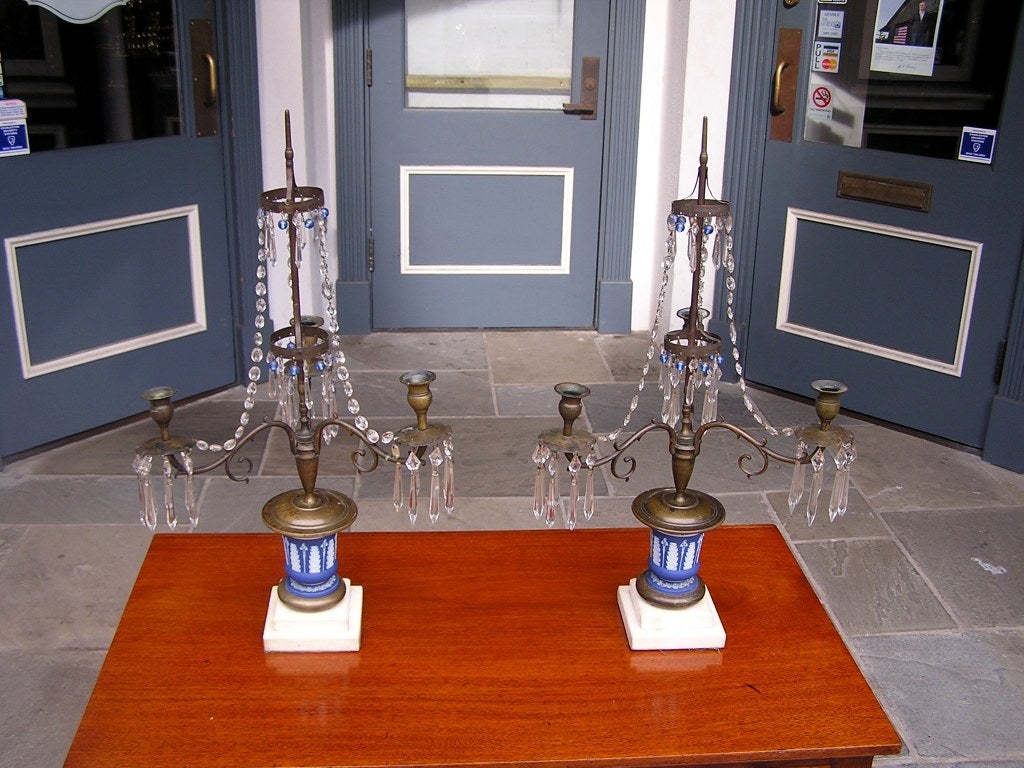 Pair of English bronze and Wedgewood two tiered candelabras with cascading prisms, cobalt blue beads, three scrolled arms, original bobeches, acanthus and ivy motif, and terminating on a two tiered step back squared marble base.  Candelabras are