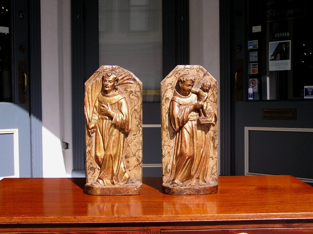 Pair of Italian gilt wood and poly chromed carvings of religious figures of man and woman with child dressed in religious attire.