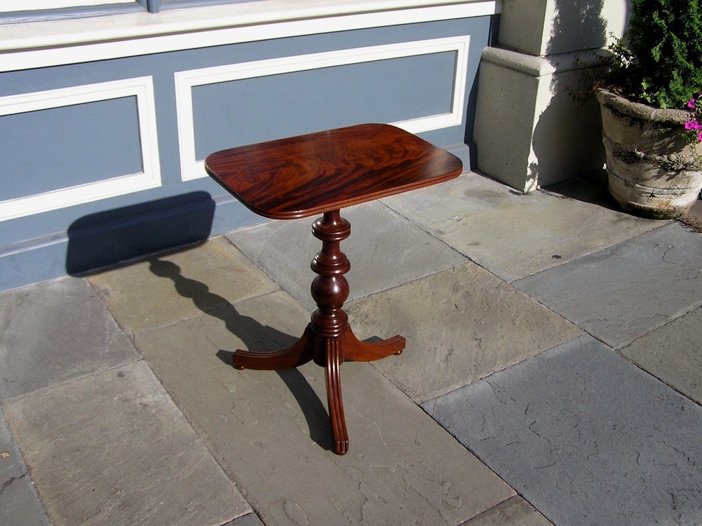 American crotch mahogany tilt top candle stand with turned bulbous pedestal terminating on tripod reeded scrolled legs with bun feet.