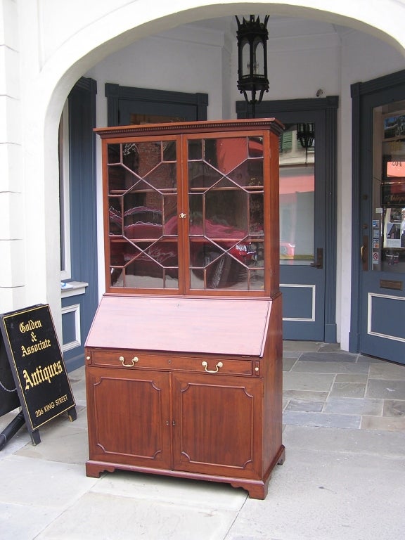 English Chippendale mahogany slant front architects secretary with adjustable upper shelves, original glass and brasses, lower fitted pull out shelving, and ending on original bracket feet.